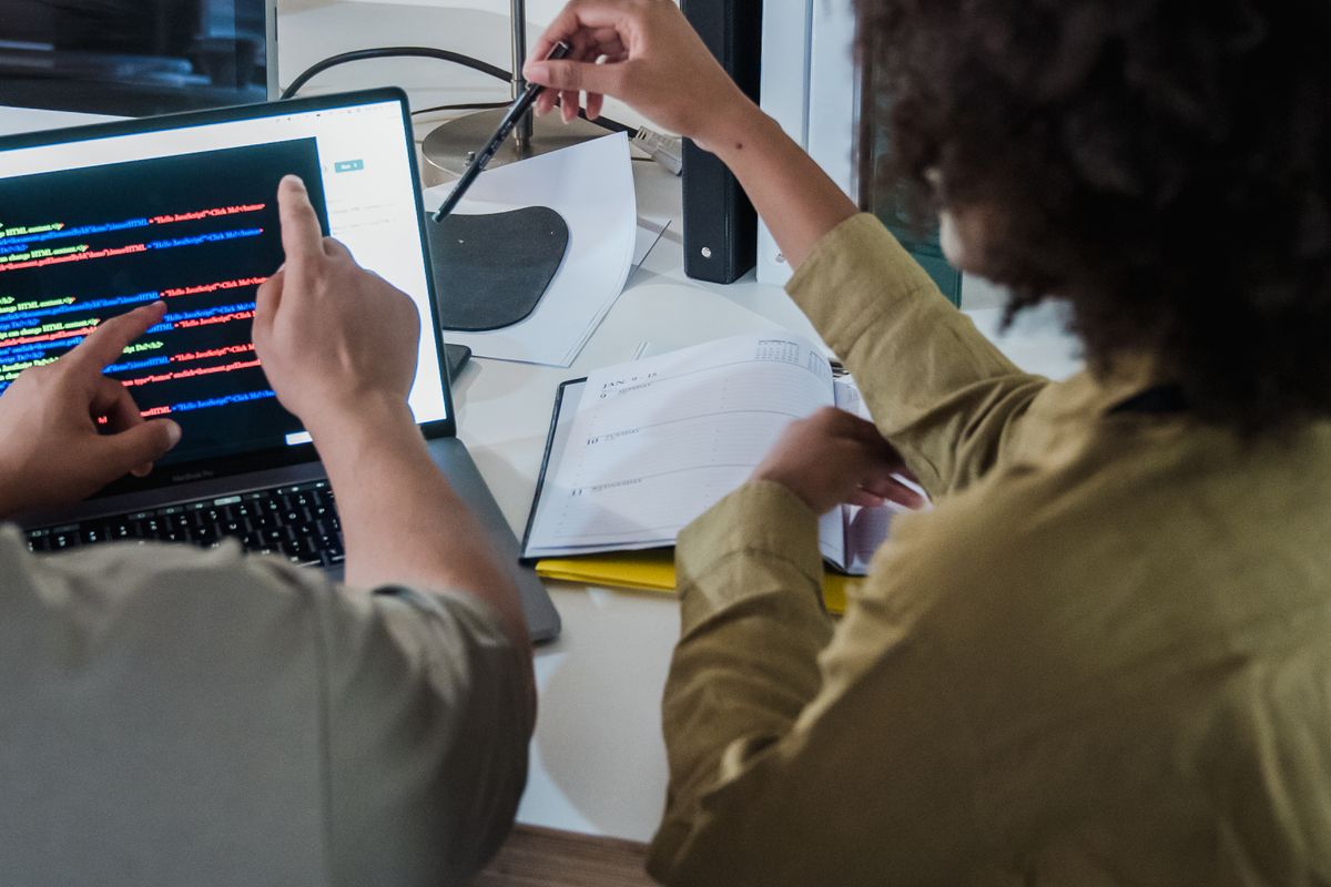 Software team reviewing code together on laptops — stock photograph